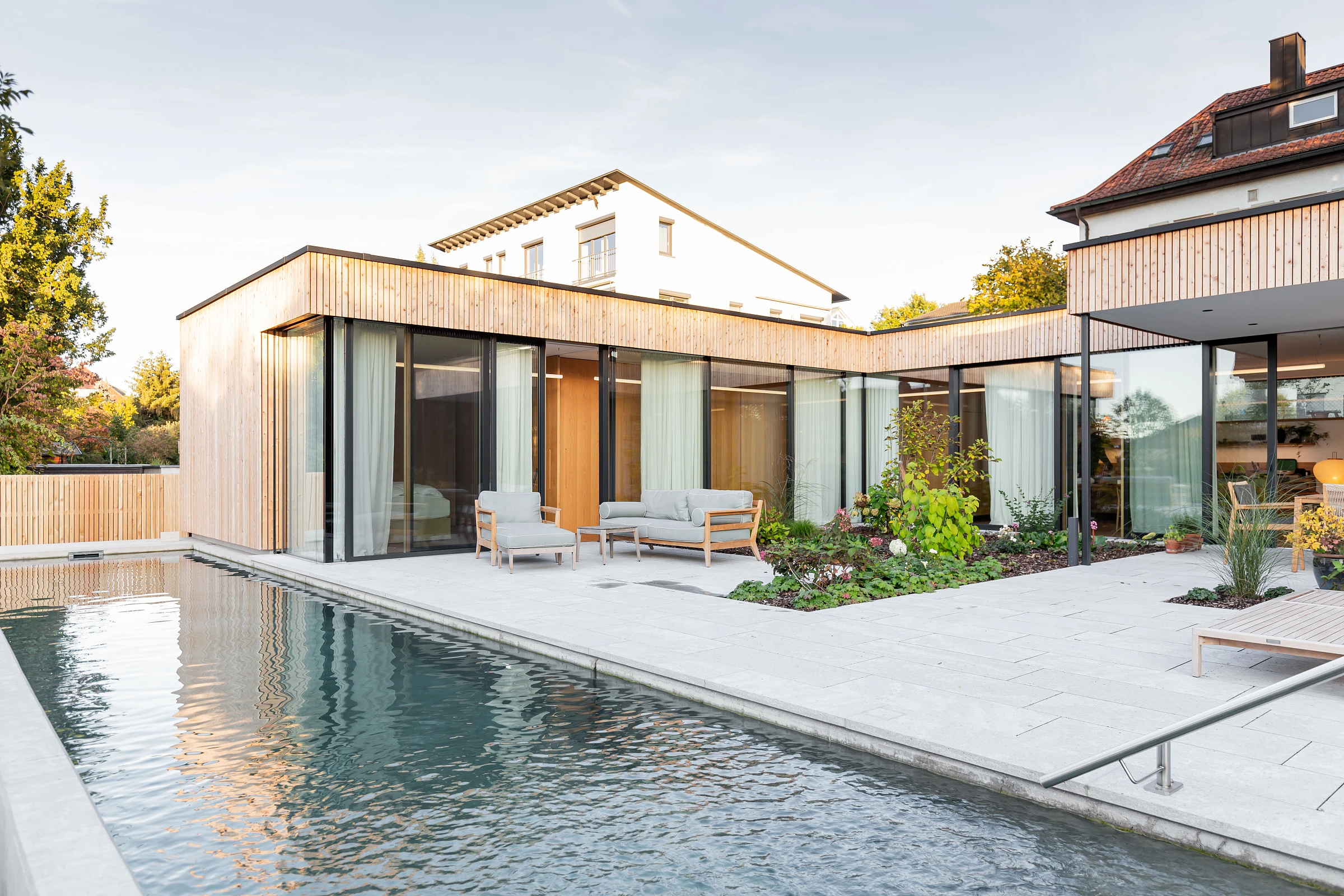 Außenansicht mit Pool eines Holzbau Einfamilienhauses