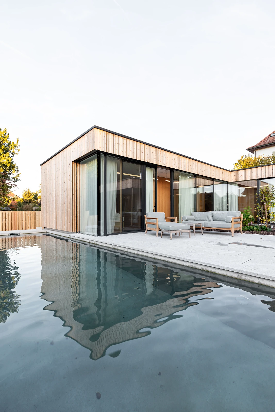 Außenansicht mit Pool eines Holzbau Einfamilienhauses