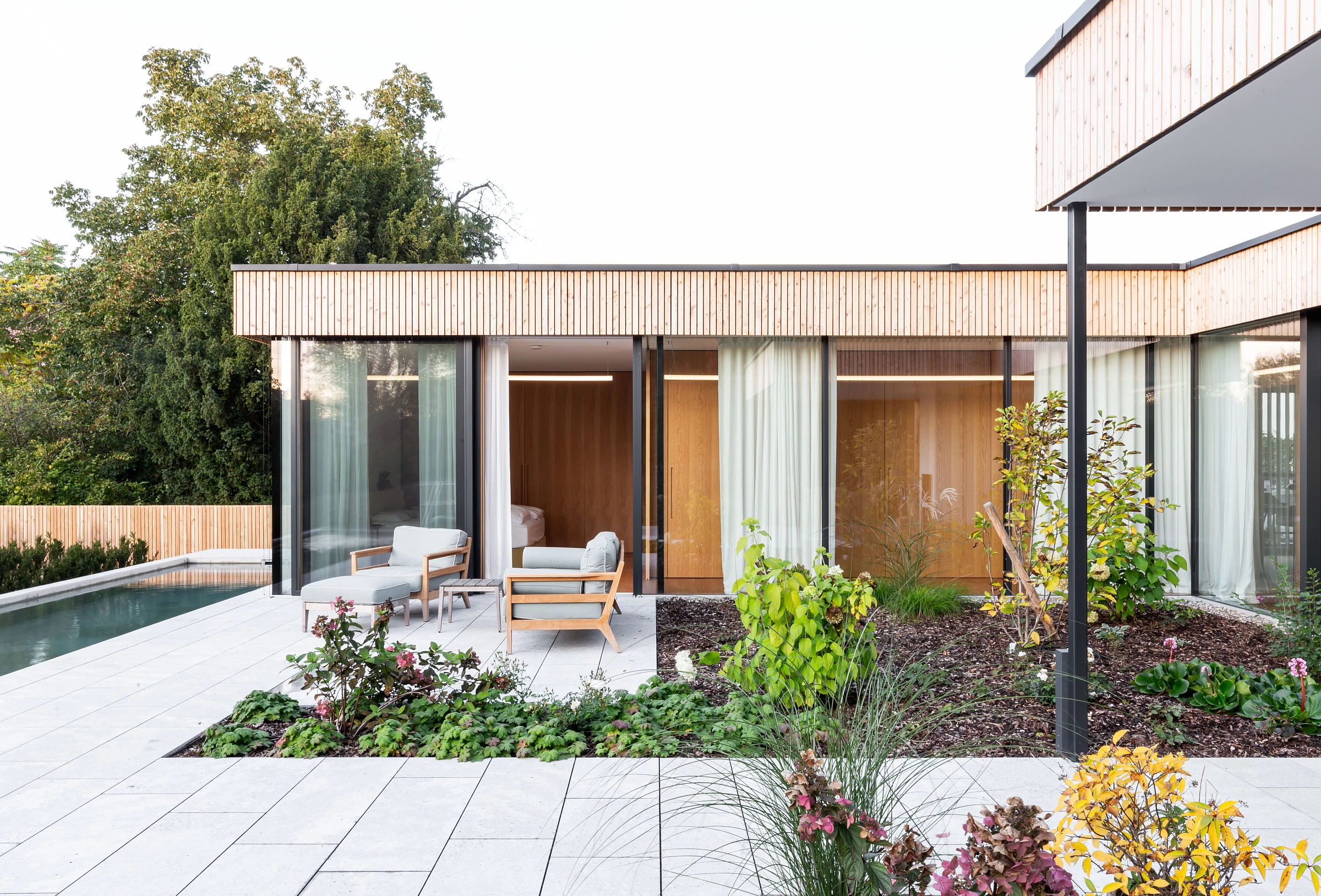 Außenansicht mit Pool eines Holzbau Einfamilienhauses