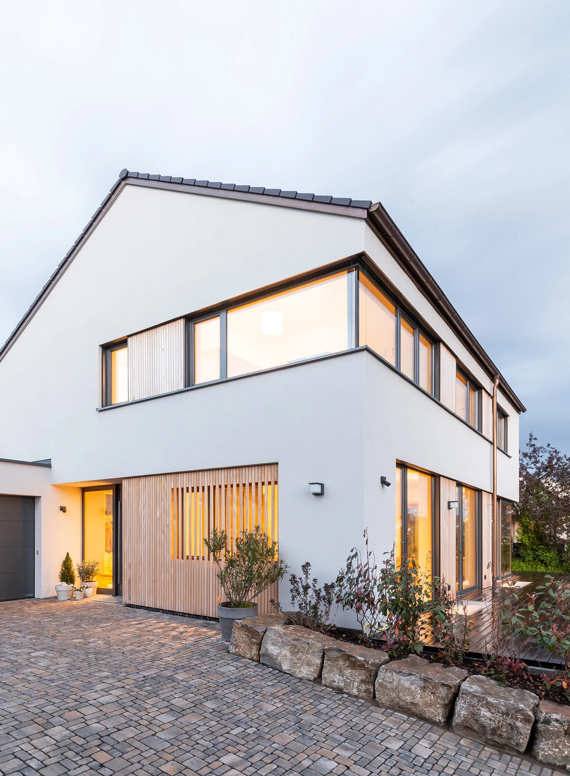 Außensicht Einfamilienhaus mit Putzfassade und Holzelementen
