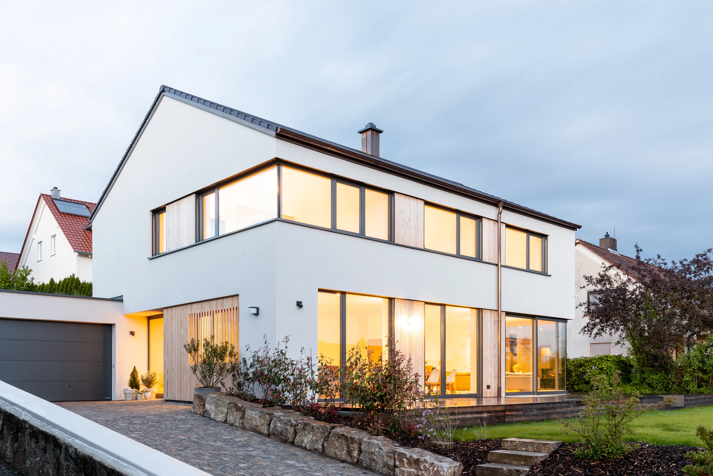 Außensicht Einfamilienhaus mit Putzfassade und Holzelementen