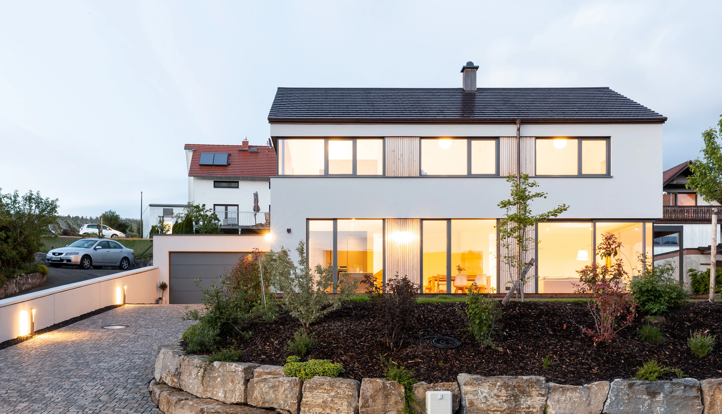 Außensicht Einfamilienhaus mit Putzfassade und Holzelementen