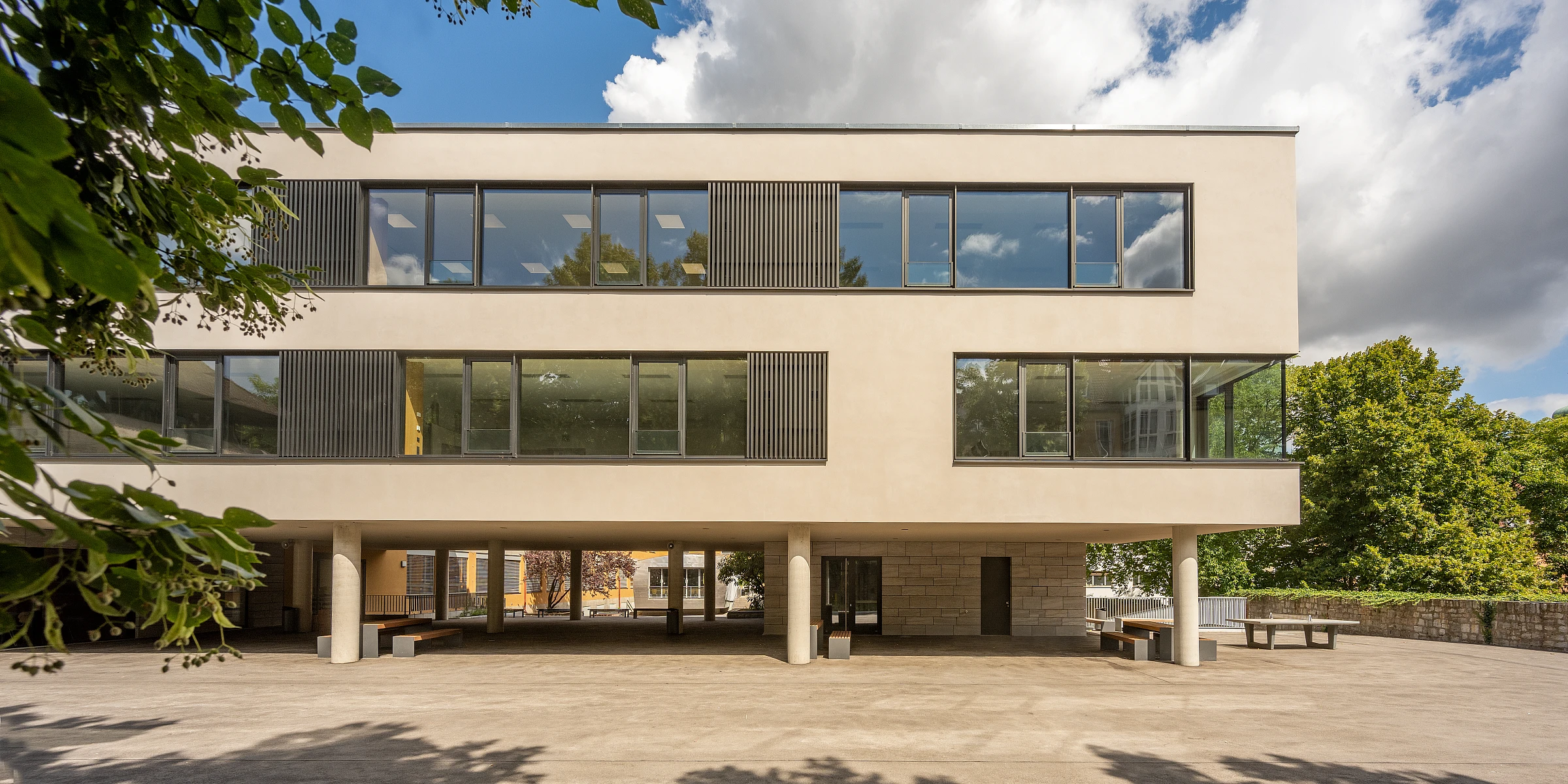 Außenansicht einer Schulerweiterung mit Fensterband und Putzfassade