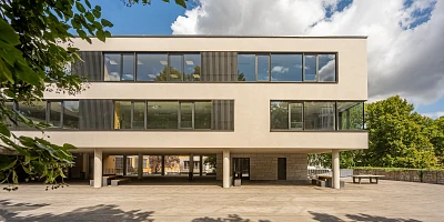 Außenansicht einer Schulerweiterung mit Fensterband und Putzfassade