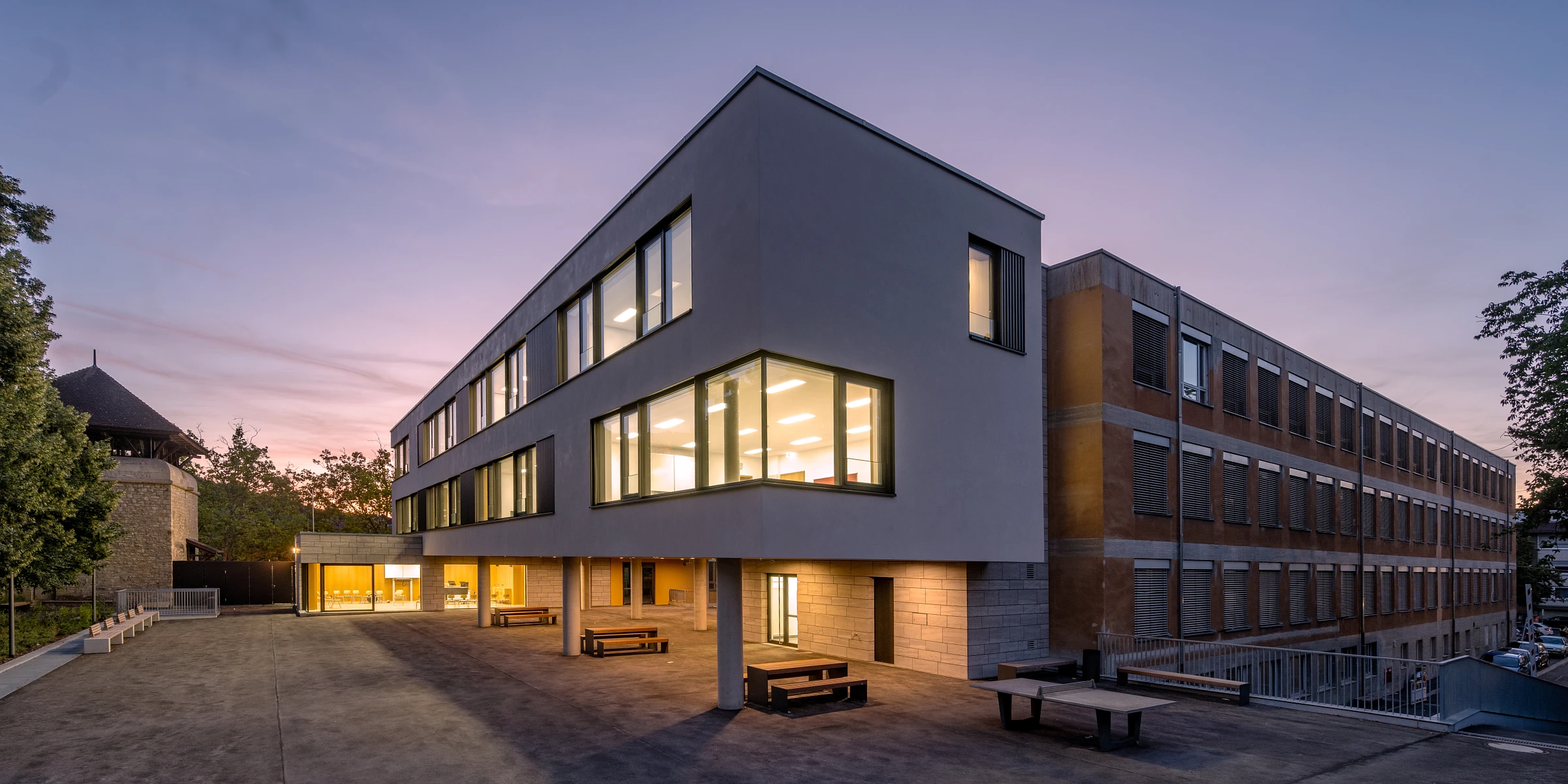 Außenansicht einer Schulerweiterung mit Fensterband und Putzfassade