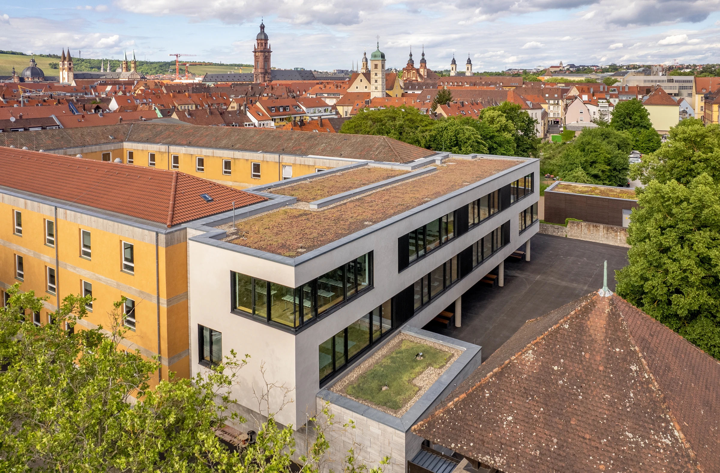 Außenansicht einer Schulerweiterung mit Fensterband und Putzfassade
