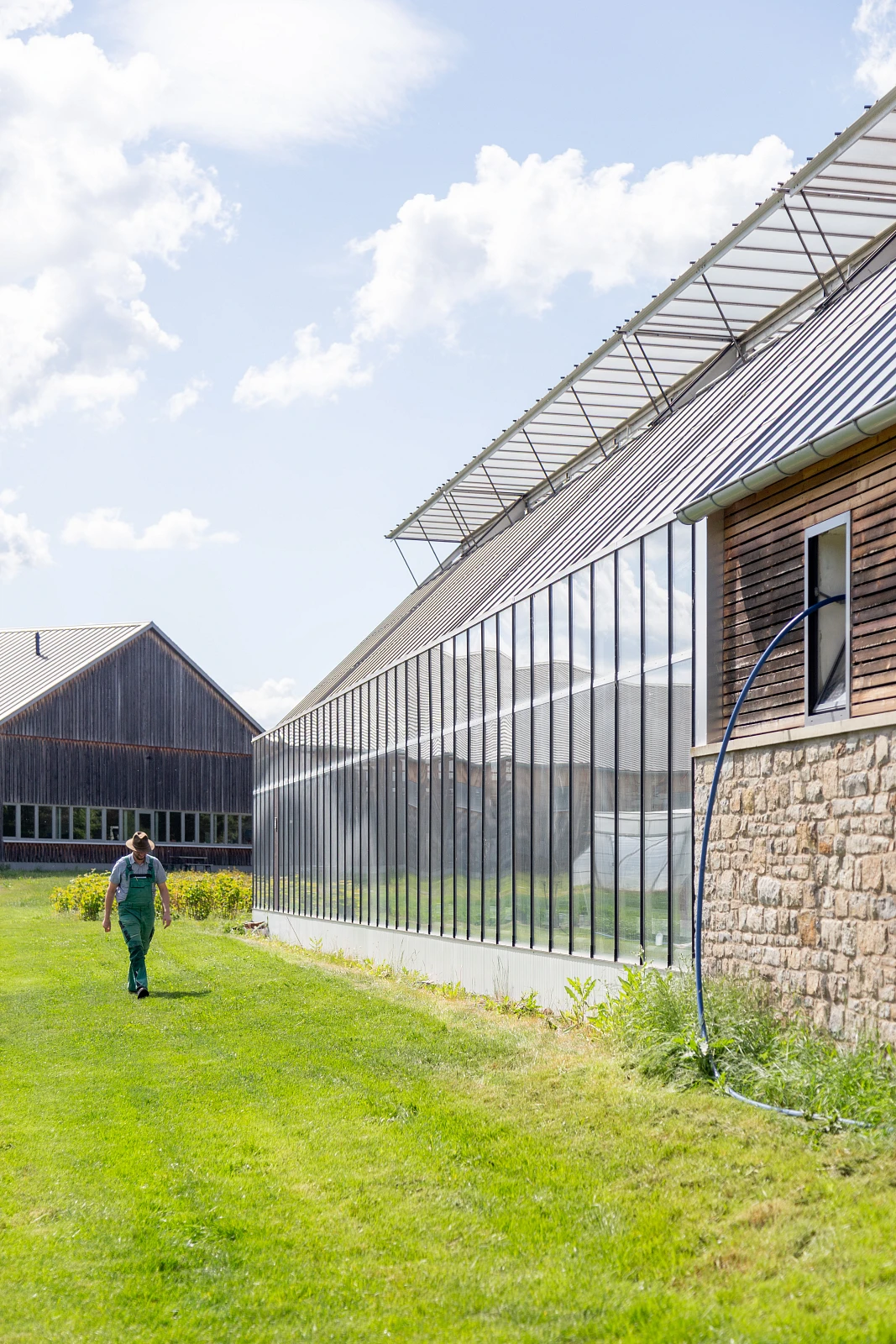 Außenansicht eines landwirtschaftlichen Gewächshauses als Anbau eines bestehenden Hofes